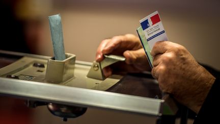 Un assesseur accepte le vote d'un électeur, dans un bureau de vote à Lille, le 6 décembre 2015. (PHILIPPE HUGUEN / AFP)