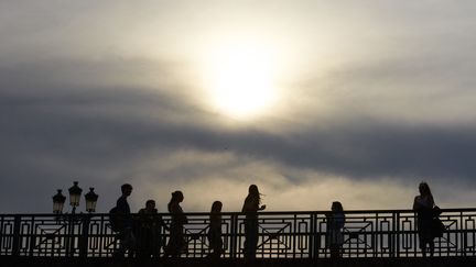 Des passants sur un pont de Toulouse (Haute-Garonne), le 4 août 2022, en pleine vague de chaleur. (ALAIN PITTON / AFP)