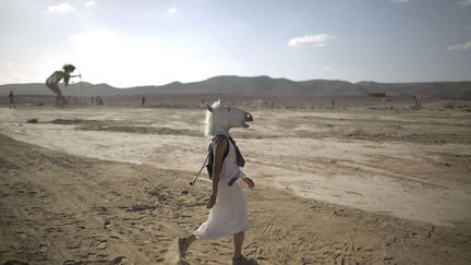 Une jeune femme portant un masque de licorne se prom&egrave;ne pr&egrave;s du kibboutz de Sde Boker (Isra&euml;l) au Midburn festival, pendant isra&eacute;lien au c&eacute;l&egrave;bre "Burning Man" am&eacute;ricain, le 6 juin 2014. (ODED BALILTY / AP / SIPA)