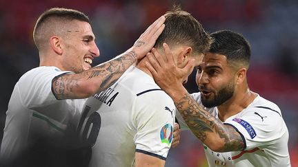 Marco Verratti (gauche) et Lorenzo Insigne (droite) félicitent Nicolo Barella (centre) après le premier but de l'Italie contre la Belgique en quarts de finale de l'Euro 2021. (CHRISTOF STACHE / AFP)