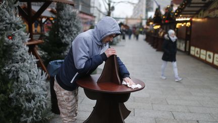 Un marchand prépare, jeudi 22 novembre 2016, la réouverture du marché de Berlin (Allemagne), touché par l'attaque au camion-bélier.&nbsp; (HANNIBAL HANSCHKE / REUTERS)