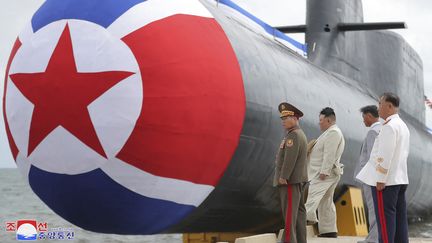 Kim Jong-un (en beige) devant un sous-marin nucléaire en Corée du Nord, le 6 septembre 2023. (KCNA VIA KNS / AFP)