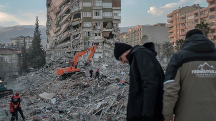 Des sauveteurs cherchent des victimes sous les décombres d'un immeuble, à&nbsp;Kahramanmaraş en Turquie, le 18 février 2023.&nbsp; (BULENT KILIC / AFP)