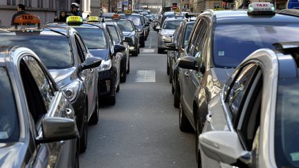 Des chauffeurs de taxi bloquent le trafic &agrave; Lyon (Rh&ocirc;ne), pour protester contre la concurrence des voitures de tourisme avec chauffeur, le 12 f&eacute;vrier 2014. (JEAN-PHILIPPE KSIAZEK / AFP)