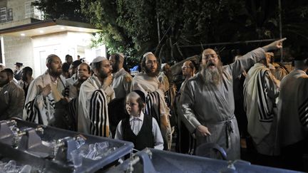 Des hommes près de la synagogue de&nbsp;Givat Zeev après l'effondrement d'un gradin, dimanche 16 mai 2021. (GIL COHEN-MAGEN / AFP)