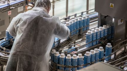 Un employé travaille sur la chaîne de production de l'usine de la société Eau Neuve (O9) produisant des briques d'eau minérale, le 7 juin 2021 à Merens-les-Vals (Ariège). (FRED SCHEIBER / AFP)