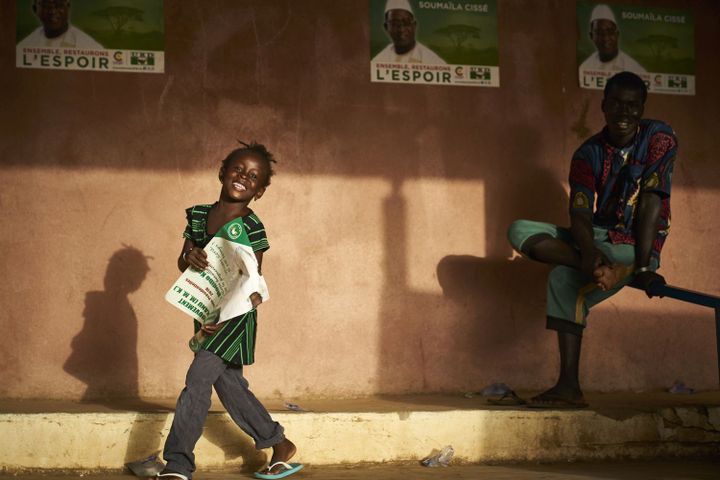 Un fillette tenant l'affiche du candidat Soumaïla Cissé, chef de file de l'opposition malienne, à Koulikro le 12 juillet 2018. (MICHELE CATTANI / AFP)