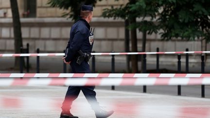 Un policier sécurise les abords de la préfecture de police de Paris, le 3 octobre 2019, après l'attaque au couteau qui a coûté la vie à quatre personnes. (IAN LANGSDON / EPA)
