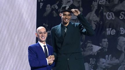 Le basketteur français Victor Wembanyama (à droite) serre la main du commissaire de la NBA Adam Silver après avoir été choisi par les San Antonio Spurs lors de la draft NBA, au Barclays Center à New York, le 22 juin 2023. (TIMOTHY A. CLARY / AFP)