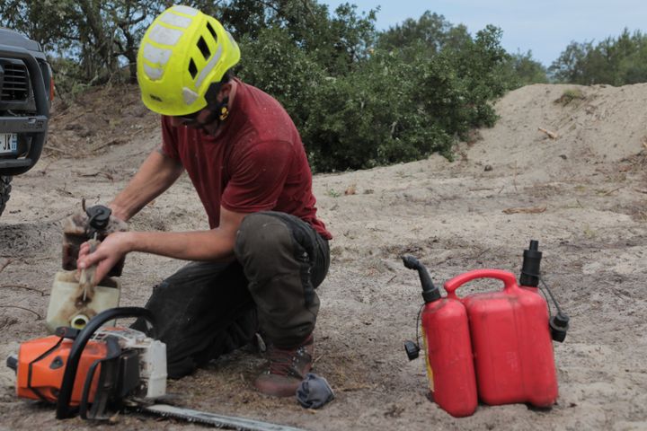 Rémi reloads his chainsaw to continue felling the trees of the firewall, on July 20, 2022 in La Teste-de-Buch.  (ELOISE BARTOLI / FRANCEINFO)