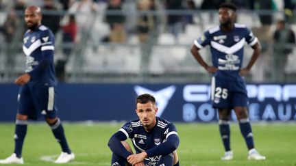 La détresse des Bordelais Rémi Oudin, Jimmy Briand et Enock Kwateng, après le nul concédé par Bordeaux contre saint-Etienne (1-1), le 20 avril 2022. (ROMAIN PERROCHEAU / AFP)