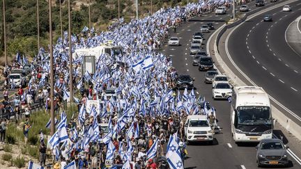 Des centaines d'Israéliens manifestent contre la réforme judiciaire le 22 juillet 2023 entre Tel Aviv et Jérusalem. (MOSTAFA ALKHAROUF / ANADOLU AGENCY / AFP)