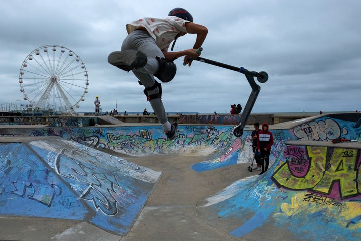 Un adolescent réalise des figures en trottinette&nbsp;au skate-park du Havre (Seine-Maritime), le 19 août 2021. (JOEL SAGET / AFP)
