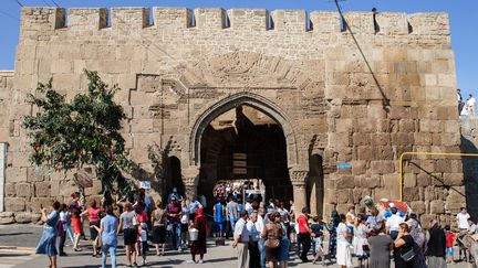 Des touristes devant la forteresse de Derbent (Daguestan, Russie), le 19 septembre 2015. Le site a été attaqué par des jihadistes le 31 décembre. (ILYAS HAJJI / AFP)