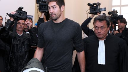 Nikola Karabatic en compagnie de son avocat Jean-Robert Nguyen Phung&nbsp;quittant le tribunal de Montpellier le 16 octobre 2012 (PASCAL GUYOT / AFP)