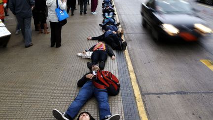 Des manifestants sont allong&eacute;s sur le trottoir &agrave; Santiago (Chili) afin de rendre hommage aux victimes de l'ancien pr&eacute;sident, Augusto Pinochet &agrave; l'occasion du 40e anniversaire du coup d'&eacute;tat, le 10 septembre 2013. (IVAN ALVARADO / REUTERS)