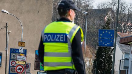 Une policière allemande surveille la frontière franco-allemande à Petite-Rosselle (Moselle), pour ne livrer passage qu'aux seuls travailleurs frontaliers, le 20 mars 2020. (OLIVER DIETZE / DPA / AFP)