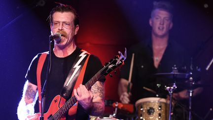 Eagles of Death Metal - Jesse Hugues et Josh Homme à la batterie au second plan, sur scène à Los Angeles le 19 octobre 2015.
 (Kevin Winter / Getty Images / AFP)