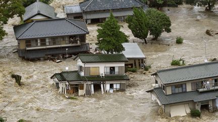 R&eacute;fugi&eacute;s sur le balcon de leurs habitations, des habitants de Joso (Japon) appellent &agrave; l'aide, jeudi 10 septembre 2015. (KYODO NEWS / AP / SIPA)