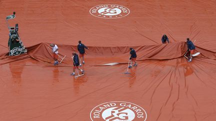 Un court de Roland-Garros bâché, sous la pluie, le 22 mai 2016. (PASCAL ROSSIGNOL / REUTERS)