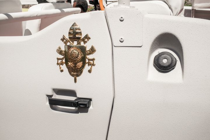 Le blason du Vatican, surmonté de la tiare papale, représentant les clés de Saint Pierre croisées sur fond de gueules, a été dûment apposé sur les portières de la papamobile. (RIJASOLO / AFP)