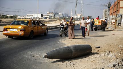 Des Palestiniens observent un bombe qui n'a pas explos&eacute;, &agrave;&nbsp;Deir Al-Balah (Gaza),&nbsp;le 1er ao&ucirc;t 2014. ( FINBARR O'REILLY / REUTERS)