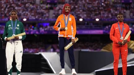 Comme le veut la tradition, les marathoniens sont honorés par un podium au moment de la cérémonie de clôture. Alors que ce sont habituellement les hommes qui, courant le plus tard dans le calendrier, sont mis en avant, ce sont cette fois les femmes qui ont eu ce privilège. Sifan Hassan (centre), Tigist Assefa (gauche) et Hellen Obiri (droite) sont ainsi récompensées. (FRANCK FIFE / AFP)