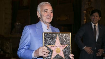 Charles Aznavour tient&nbsp;une étoile honorifique, le 27 octobre 2016 à Hollywood (Californie, Etats-Unis), semblable à celle qui sera cimentée sur le Walk of Fame. (JONATHAN ALCORN / AFP)