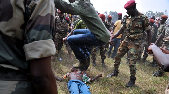 Un homme en civil saute &agrave; pieds joints sur un homme accus&eacute; d'&ecirc;tre un ancien rebelle, le 5 f&eacute;vrier 2014 &agrave; Bangui (Centrafrique).&nbsp; (ISSOUF SANOGO / AFP)