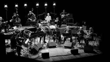 Régis Huby (assis à la gauche de la scène) dirige l'ensemble The Ellipse à D'Jazz Nevers, au Théâtre municipal (13 novembre 2018)
 (Maxim François)