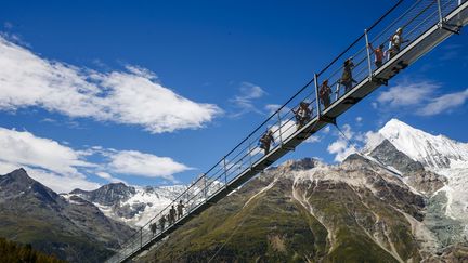 Des visiteurs sur le pont suspendu le plus long du monde, près de Randa, en Suisse, le 29 juillet 2017. (VALENTIN FLAURAUD / AP / SIPA)