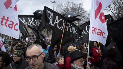 Des pancartes ornées du nom du&nbsp;gestionnaire d'actifs BlackRock lors d'une manifestation contre la réforme des retraites à Paris, le 17 décembre 2019. (NICOLAS PORTNOI / HANS LUCAS / AFP)