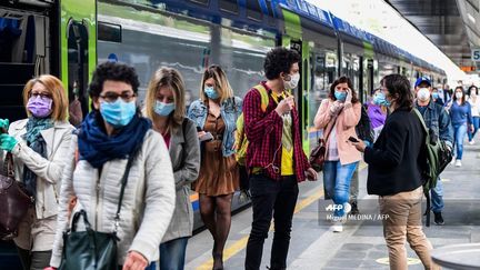 Des voyageurs sur un quai de la gare de Milan-Carona (Italie), le 4 mai 2020. (MIGUEL MEDINA / AFP)