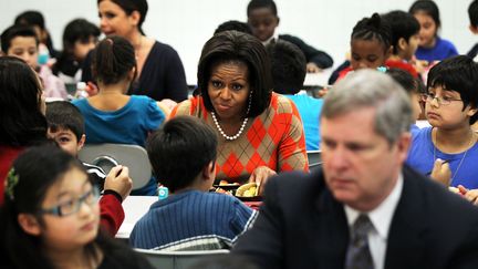 Michelle Obama accompagne des enfants dans une cantine scolaire pour promouvoir son programme de lutte contre l'obésité infantile, le 25 janvier 2012 à Alexandria (Virginie). (ALEX WONG / GETTY IMAGES NORTH AMERICA / AFP)