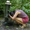 Une femme s'arrose sous une fontaine lors d'un épisode de forte chaleur, à Clamart (Hauts-de-Seine), le 10 septembre 2023. (MAGALI COHEN / HANS LUCAS / AFP)