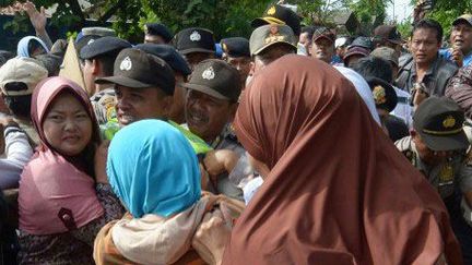 La police tente de séparer le 23 décembre 2012 des habitants musulmans du village de Jejalen Jaya (ouest de Java) de protestants de la communauté batak. Ceux-ci souhaitent célébrer leur culte dans une propriété qui leur appartient sur le territoire de la commune. (AFP - ADEK BERRY)