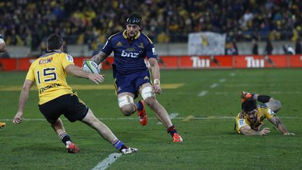 Le 3e ligne des Highlanders, Elliot Dixon, auteur du premier essai de son équipe, face à l'arrière James Marshall (ANTHONY PHELPS / AFP)