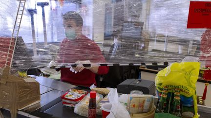 Un caissier de supermarché protégé par un film plastique pendant l'épidémie de Covid-19, à Montpellier (Hérault). Photo d'illustration.
 (GUILLAUME BONNEFONT / MAXPPP)