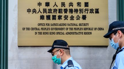 Des policiers devant le bureau de défense de la sécurité nationale du régime chinois à Hong Kong, le 8 juillet 2020.&nbsp; (ANTHONY WALLACE / AFP)