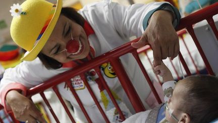 Un bébé s'accroche au doigt d'une membre de «Laughter Doctors of Ciudad Juarez» dans l'hôpital pour enfants de la ville de Ciudad Juarez, au Mexique, le 11 mars 2015. 
 (REUTERS/Jose Luis Gonzalez)