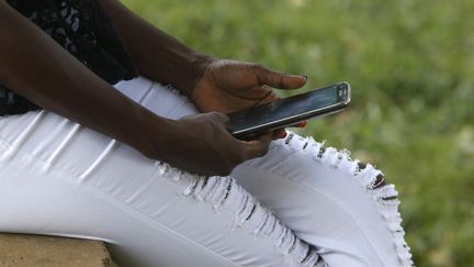 Une Africaine utilise un téléphone portable (photo prise le 3 mars 2017).&nbsp; (AFP - GODONG / BSIP)