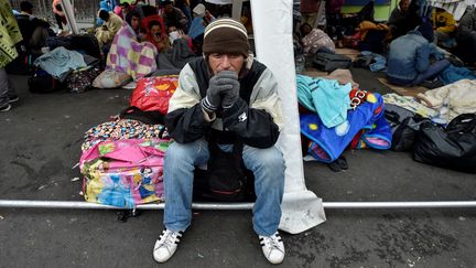 Un Vénézuelien patiente devant le bureau équatorien de l'immigration, à la frontière entre Tulcan (Equateur) et Ipiales (Colombie), le 20 août 2018. (LUIS ROBAYO / AFP)