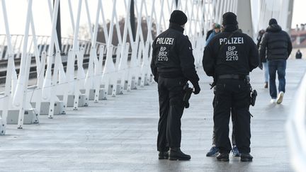 Des policiers allemands qui contrôlent des piétons à la frontières entre la France et l'Allemagne à Kehl. (SEBASTIEN BOZON / AFP)