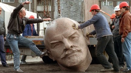 Une image du 13 novembre 1991 montre des ouvriers déplacer la statue géante de Lénine à Berin.
 (BERND SETTNIK / DPA / AFP)