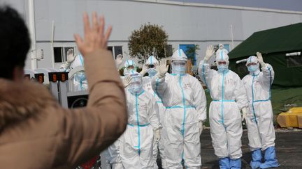 Des soignants disent au revoir à un patient guéri du Covid-19, le 1er mars 2020, à l'hôpital Leishenshan de Wuhan (Chine). (CHINA DAILY CDIC / REUTERS)