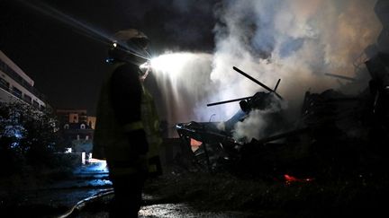 Un pompier sur les lieux de l'incendie qui a ravagé deux immeubles inhabités à Rouen (Seine-Maritime), dimanche 1er octobre 2023. (LOU BENOIST / AFP)