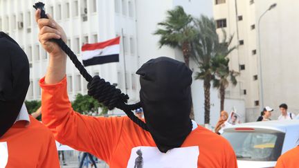 Une personne manifeste à Tunis (Tunisie) pour protester contre des peines de mort prononcées par la justice du pays, le 29 mai 2015. (YASSINE GAIDI / ANADOLU AGENCY / AFP)