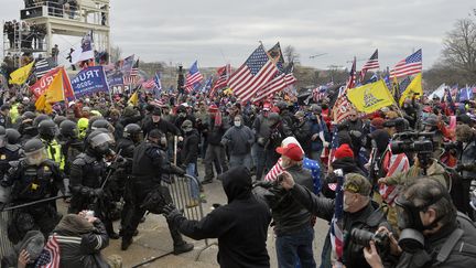 Des participants à l'attaque du Capitole affrontent les forces de sécurité le 6 janvier 2021 à Washington, aux Etats-Unis. (JOSEPH PREZIOSO / AFP)