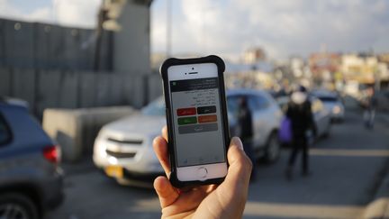 A Ramallah, un palestinien utilise l'application Azmeh sur son smartphone, une application développée pour aider à la navigation des automobilistes, en février 2016. (ABBAS MOMANI / AFP)