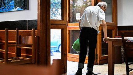 Un vieil homme vient récupérer un sac de nourriture à une soupe populaire en Italie, le 20 septembre 2022. (ALBERTO PIZZOLI / AFP)